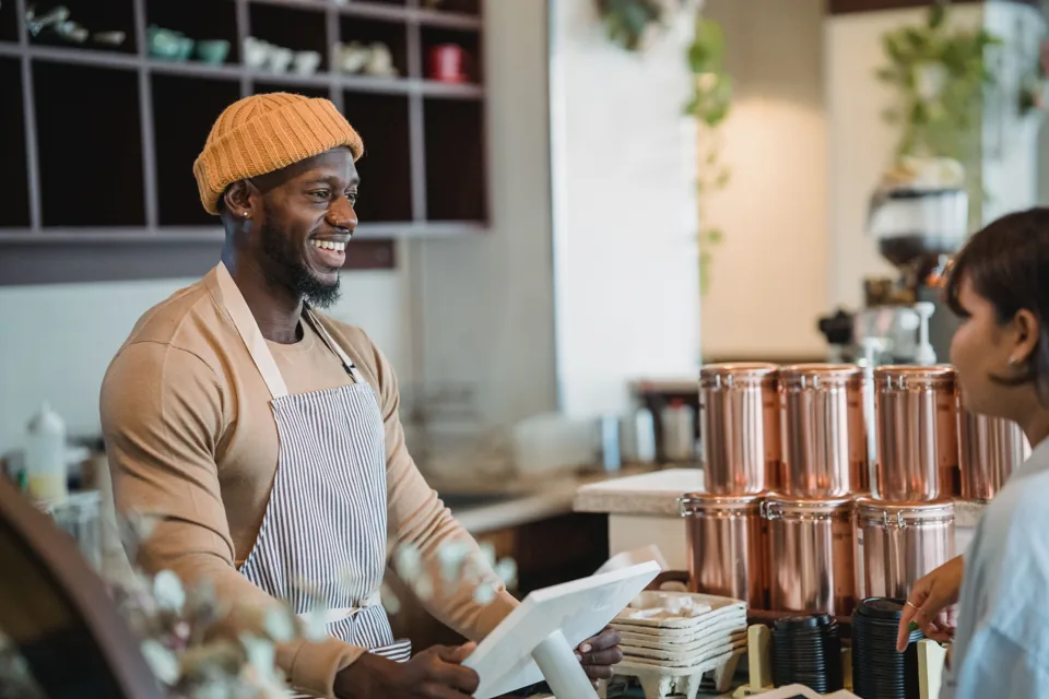 A café owner welcoming the neighborhood into his shop.