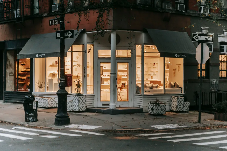 A neighborhood corner shop with warmly lit windows.